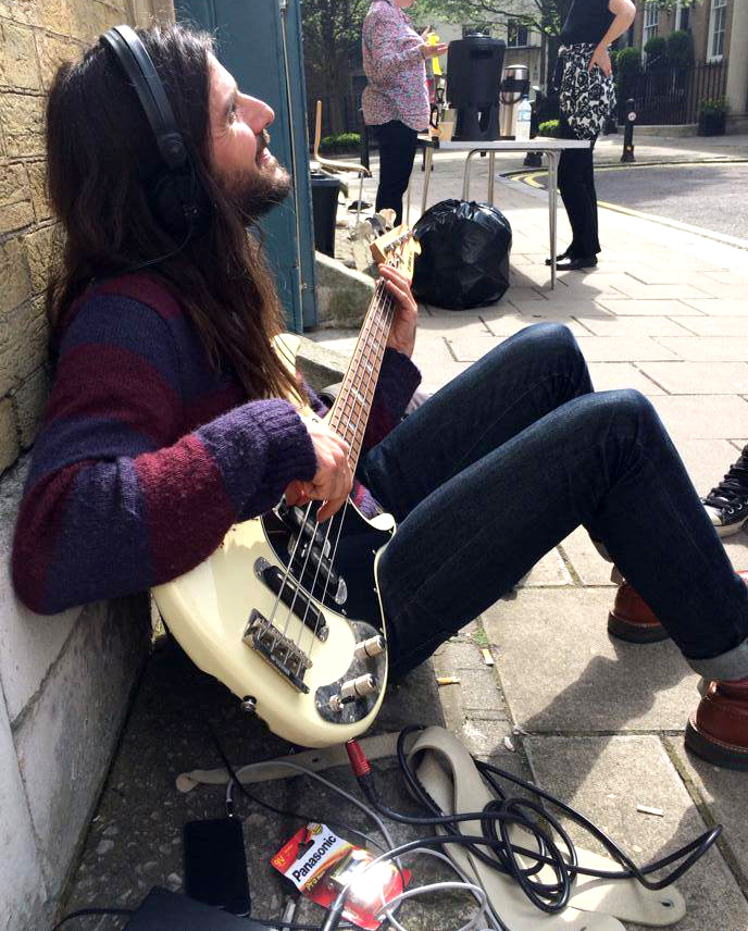 Bass player Nick Fyffe preparing in the sun outside St. Mary's church. Photo: Sunflower Jam